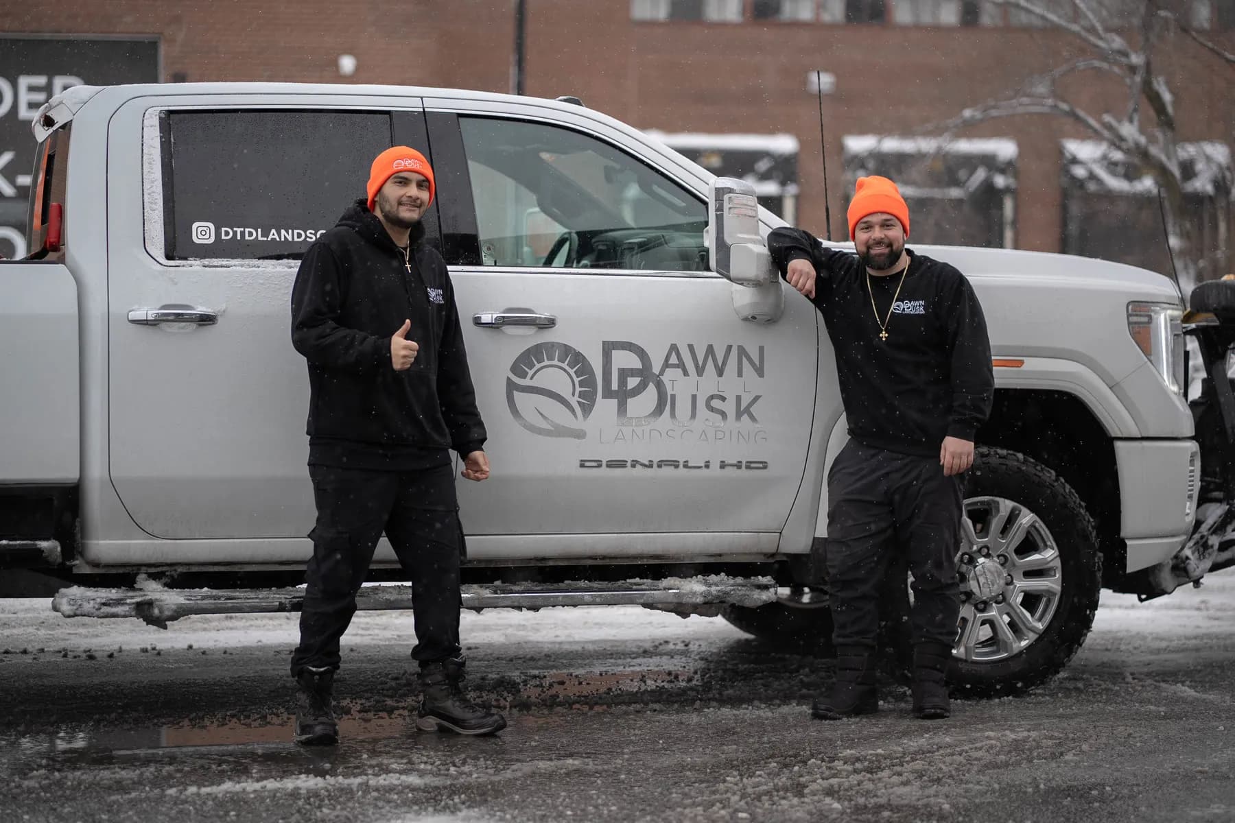Ted and crew member at the Dawn Till Dusk truck door logo during a winter shoot