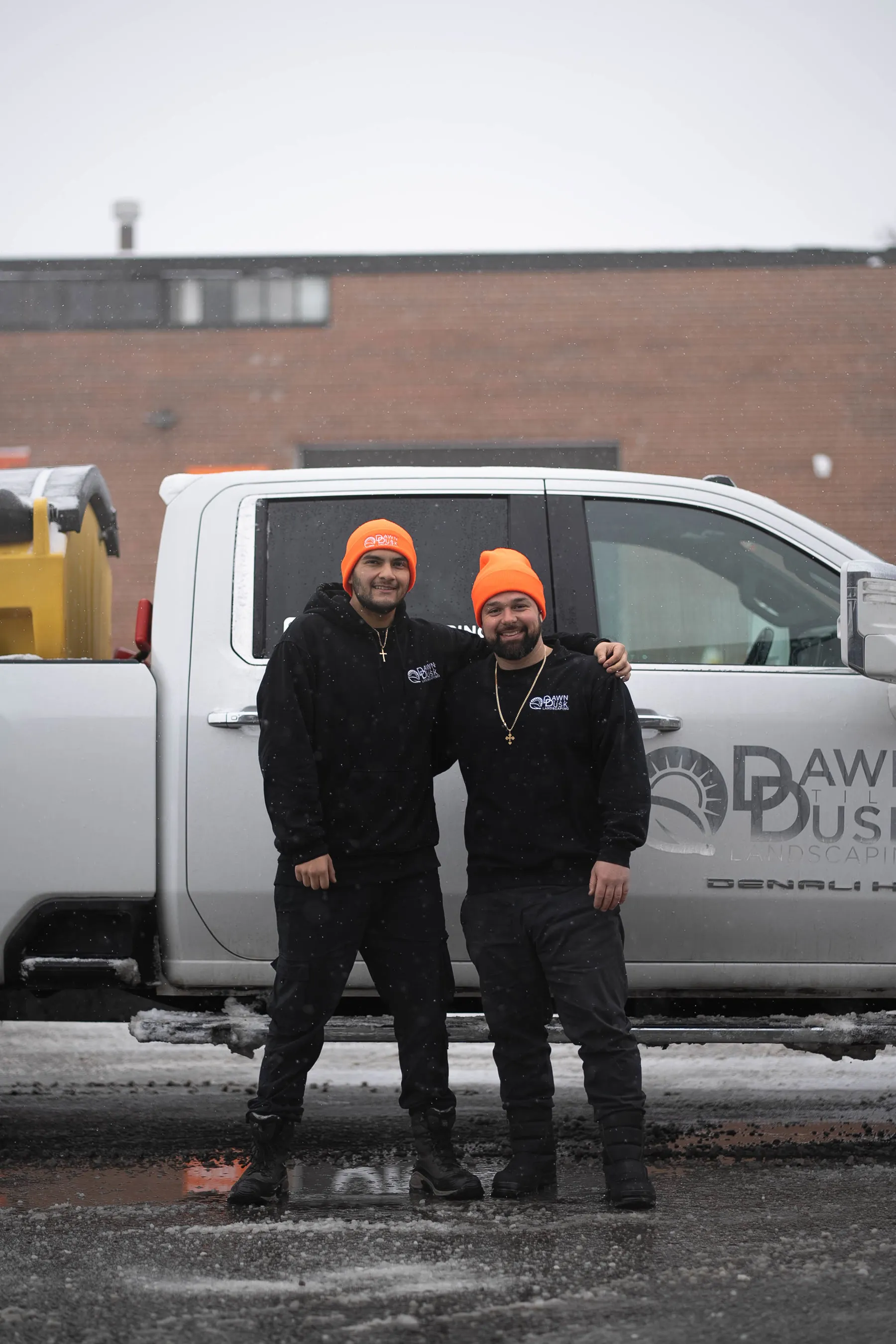 Dawn Till Dusk crew in front of the plow truck after a snow clearing route
